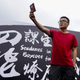 A mainland Chinese student holds up his China passport in defiance of protesting Hong Kong students during a strike on the first day of school at the Chinese University of Hong Kong.
